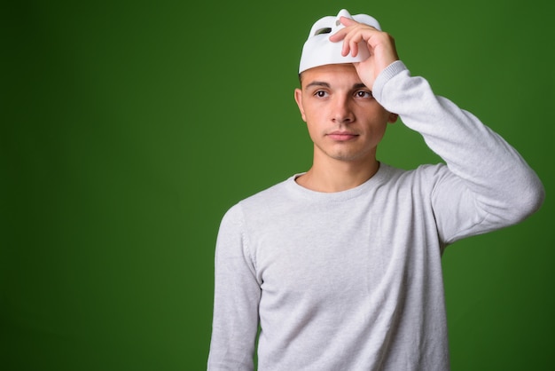 Studio shot van de jonge knappe man tegen een groene achtergrond