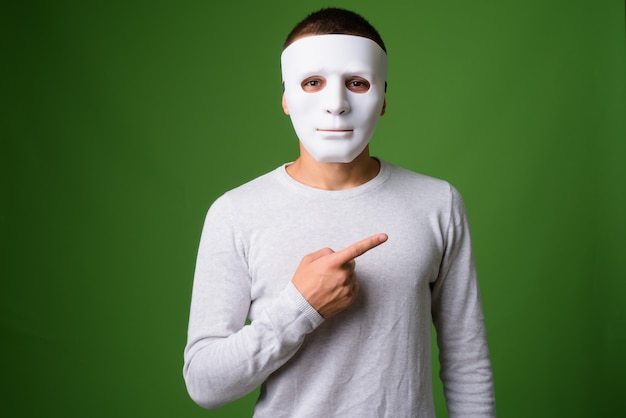 Studio shot van de jonge knappe man tegen een groene achtergrond