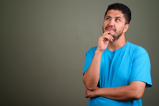 Studio shot van een bebaarde man met blauw shirt tegen gekleurd