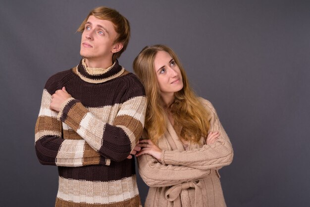 Studio shot van een jong koppel samen tegen een grijze muur