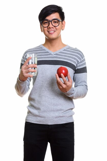 Studio shot van gelukkig Aziatische man glimlachend terwijl rode appel a