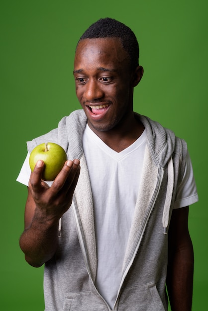 Studio shot van jonge Afrikaanse man tegen een groene achtergrond