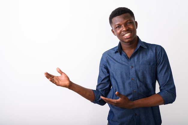 Studio shot van jonge gelukkig zwarte Afrikaanse man die lacht