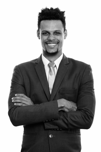 Studio shot van jonge knappe bebaarde Afrikaanse zakenman in pak geïsoleerd tegen een witte achtergrond in zwart-wit