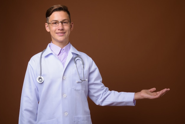 Studio shot van jonge knappe dokter tegen bruine achtergrond