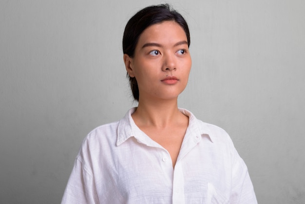 Studio shot van jonge mooie vrouw met haar vastgebonden tegen wit