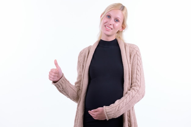 Studio shot van jonge mooie zwangere vrouw met blond haar geïsoleerd tegen een witte achtergrond