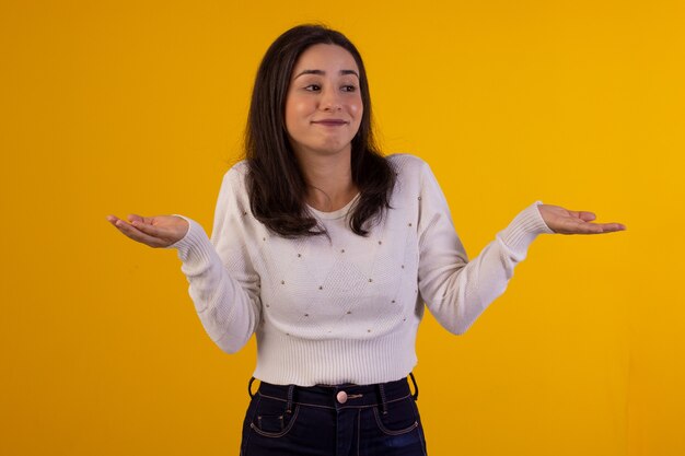 Studio shot van jonge vrouw in wit overhemd op gele achtergrond met verschillende gezichtsuitdrukkingen