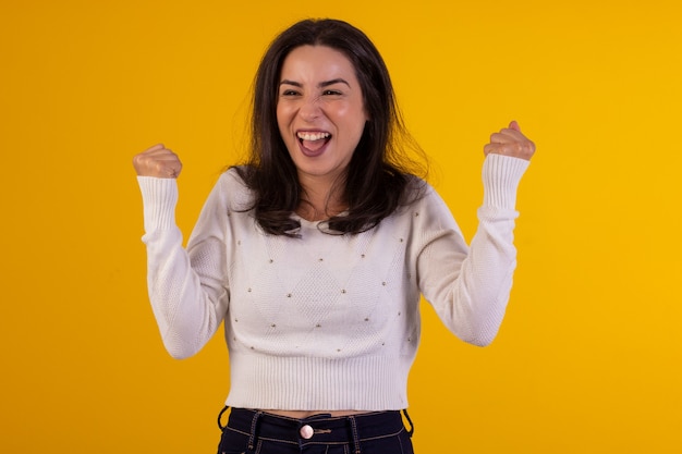 Studio shot van jonge vrouw in wit overhemd op gele achtergrond met verschillende gezichtsuitdrukkingen