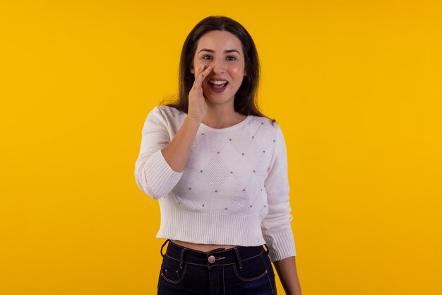 Studio shot van jonge vrouw in wit overhemd op gele achtergrond met verschillende gezichtsuitdrukkingen