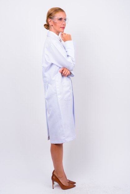 Studio shot van mooie blonde vrouw arts als wetenschapper met beschermende bril tegen witte achtergrond