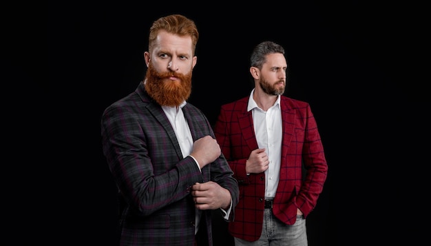 Studio shot van twee knappe mannen in herenkleding jassen mannen in herenkleding geïsoleerd op zwarte achtergrond