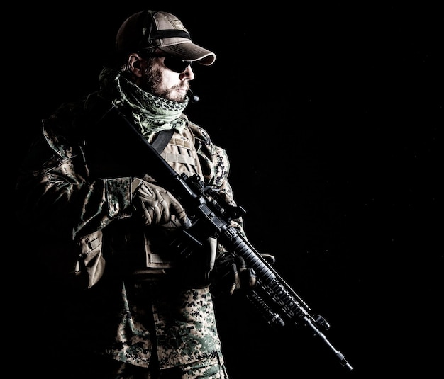 Studio shot van United States Marine met geweerwapens in uniformen. Militaire uitrusting, legerhelm, gevechtslaarzen, tactische handschoenen. Geïsoleerd op zwart, wapens, leger, patriottisme concept