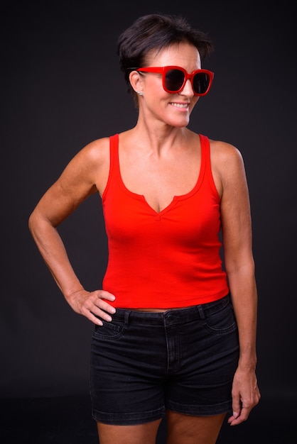 Studio shot van volwassen mooie Scandinavische vrouw met kort haar tegen zwarte achtergrond