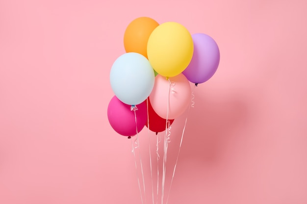 Studio shot with soft shadow of beautiful bright and colorful air balloons, isolated on pink colored background with copy space for advertising. Birthday party, events, woman's day and summer concepts