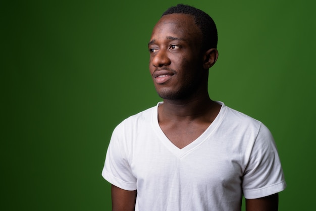 Studio shot of young African man against green background