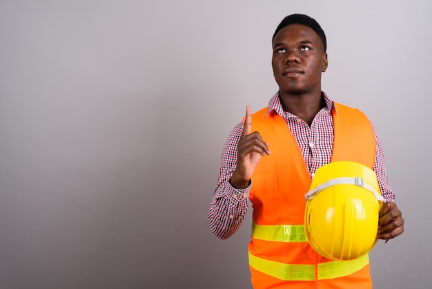 Studio shot of young African man construction worker against white background