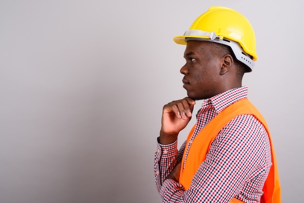 Studio shot of young African man construction worker against white background