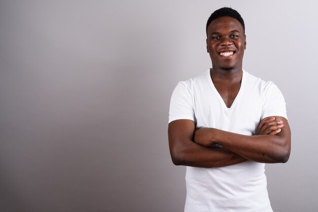 Studio shot of young African man wearing white shirt against white background