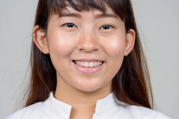 Studio shot of young Asian woman against white background