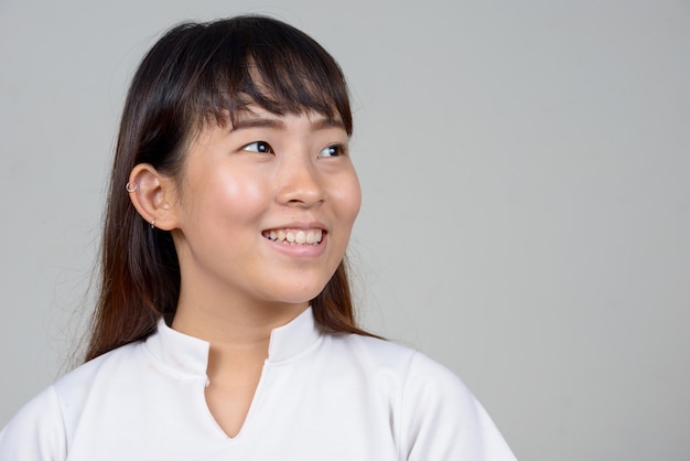 Studio shot of young Asian woman against white background