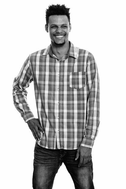 Studio shot of young bearded African businessman with afro hair isolated against white background in black and white