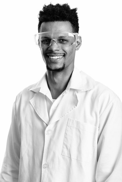 Студийный снимок молодого бородатого африканского доктора-доктора в защитных очках, изолированных на белом фоне в черно-белом