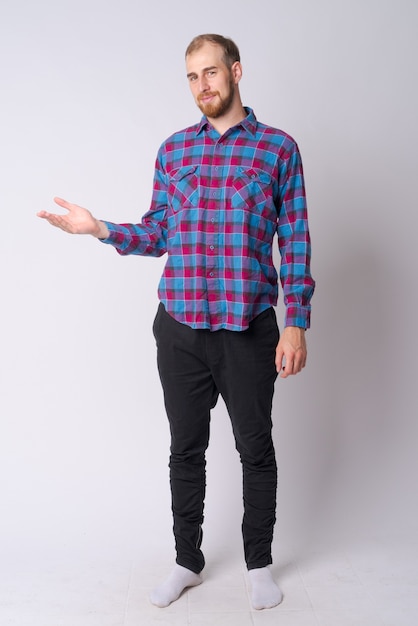 Studio shot of young bearded hipster man against white