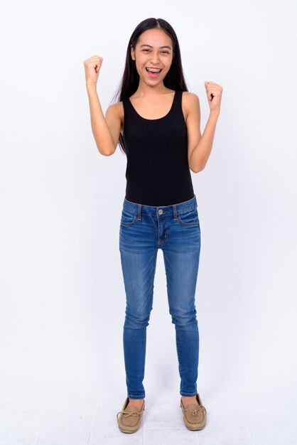 Studio shot of young beautiful Asian woman against white background