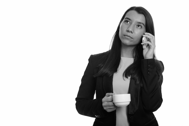 Studio shot of young beautiful businesswoman isolated against white background in black and white