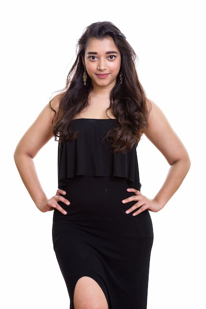 Studio shot of young beautiful Indian woman standing with hands