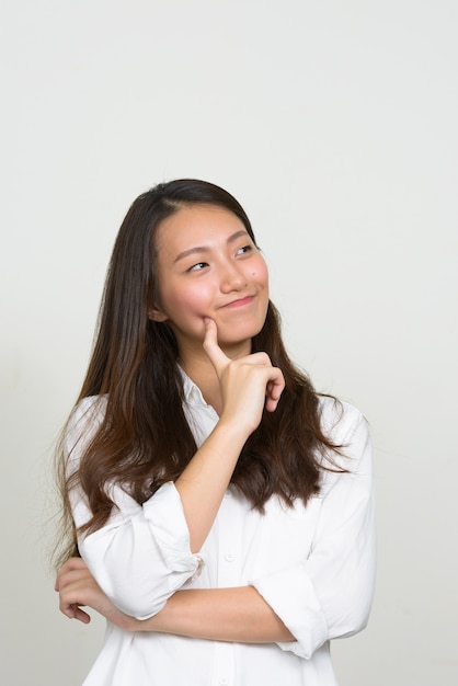 Studio shot di giovane bella imprenditrice coreana su sfondo bianco