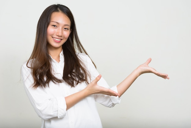 Studio shot of young beautiful Korean businesswoman against white background