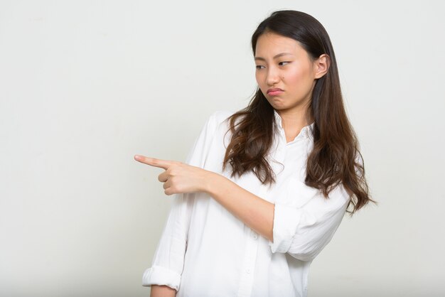 Studio shot of young beautiful Korean businesswoman against white background