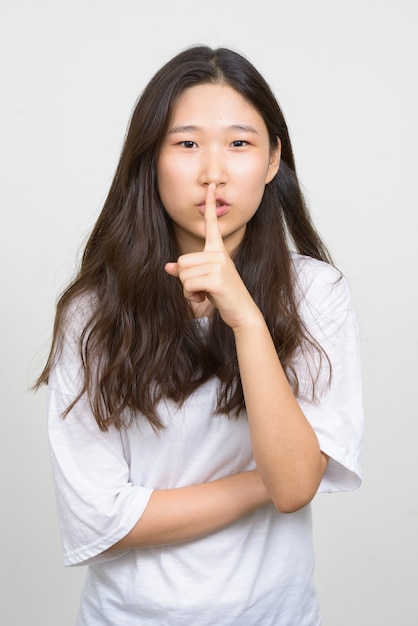 Studio shot of young beautiful Korean woman against white background