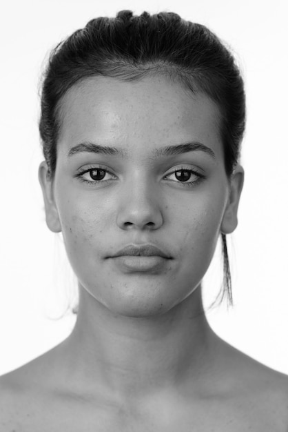 Studio shot of young beautiful multi ethnic teenage girl with short hair isolated against white background in black and white