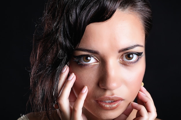 Studio shot of young beautiful woman on dark surface