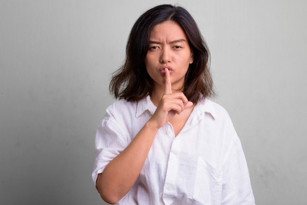 Studio shot of young beautiful woman with short hair against white