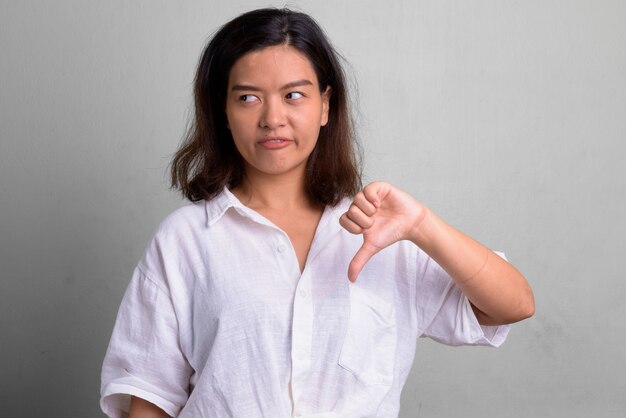 Studio shot of young beautiful woman with short hair against white