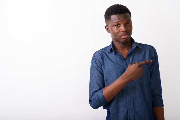 Studio shot of young black African man pointing