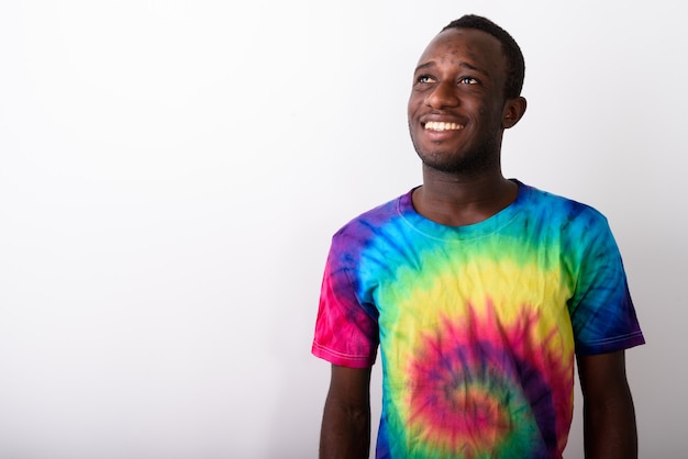 Studio shot of young black African man smiling and looking up wh