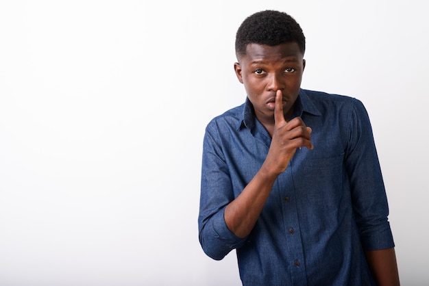 Studio shot of young black African man with finger on lips