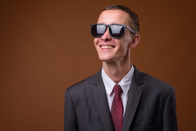 Studio shot of young businessman on brown