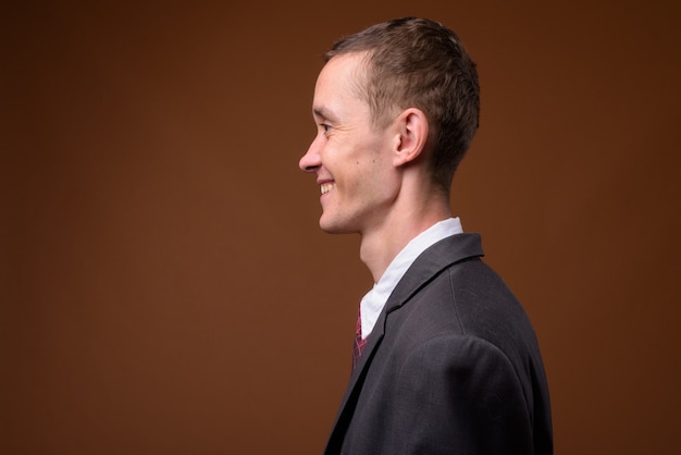 Studio shot of young businessman on brown