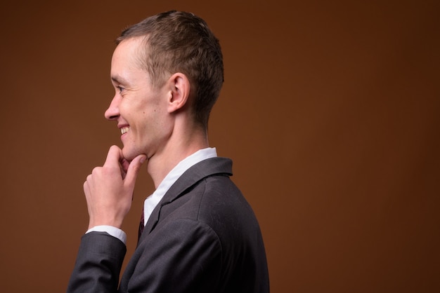 Studio shot of young businessman on brown