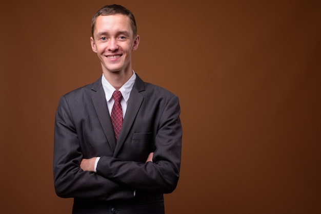 Studio shot of young businessman on brown