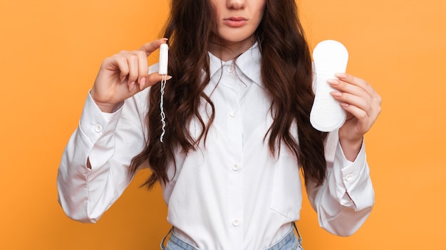 Studio shot of a young girl holding a Panty liner and tampons for menstruation The concept of feminine hygiene