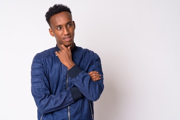 Studio shot of young handsome African man with Afro hair against white