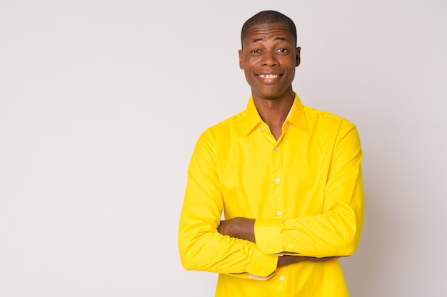 Studio shot of young handsome bald African businessman against white background