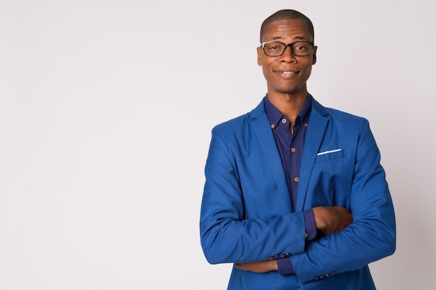 Studio shot of young handsome bald African businessman in suit with eyeglasses against white background